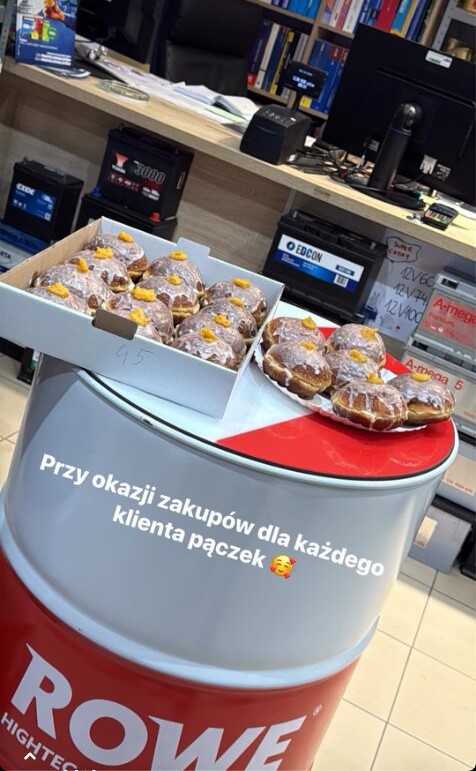 Pączki dla klientów w Tłusty Czwartek Auto Woźnicki na sklepowej ladzie.