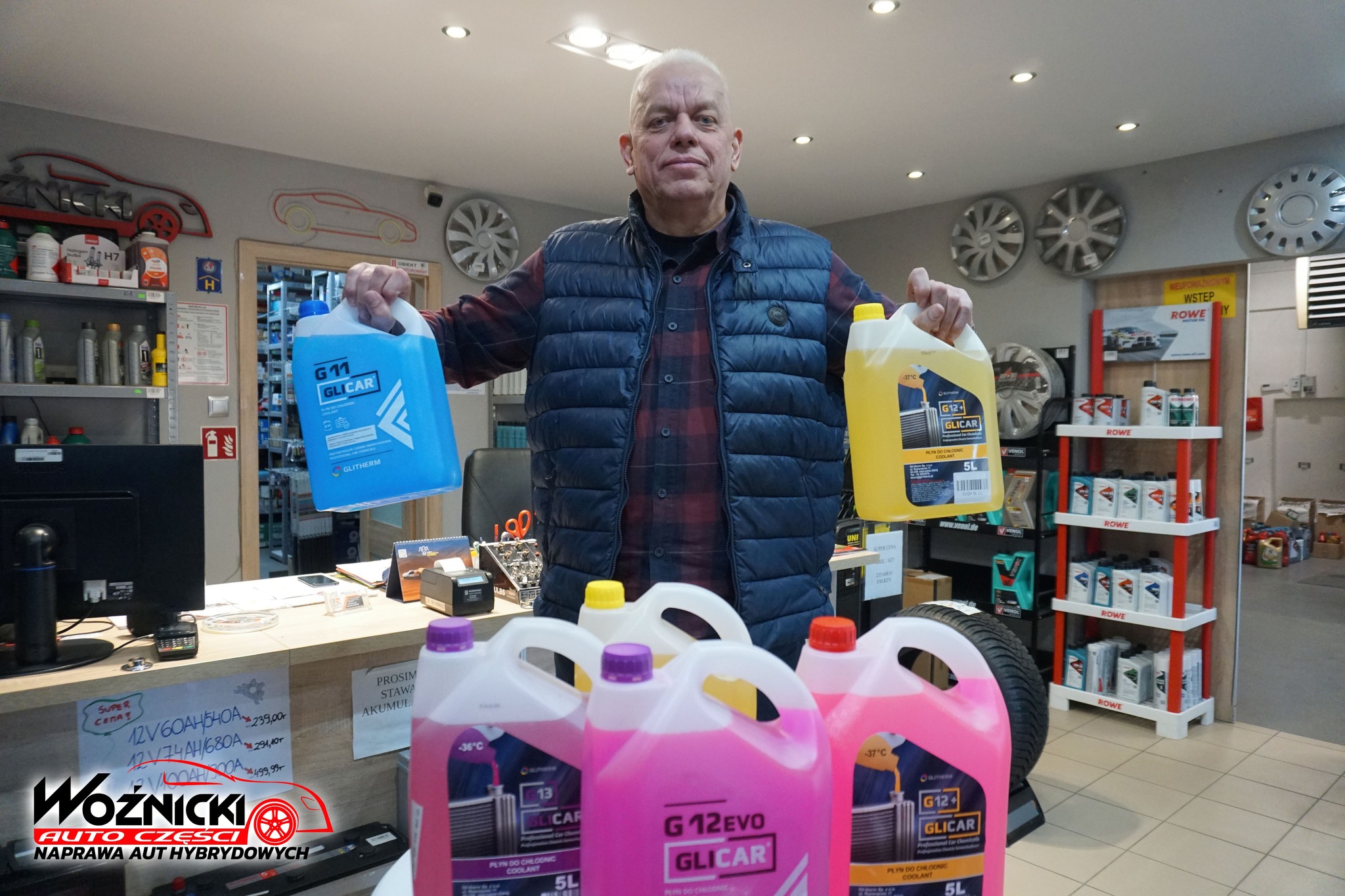 GLICAR G12 EVO płyn do chłodnic prezentowany w sklepie Auto Woźnicki przez Dariusza Woźnickiego na tle jednego ze sklepów.